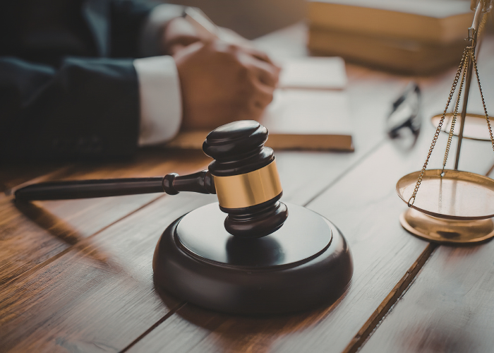 Gavel and scales of justice beside legal documents
