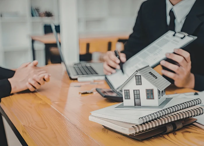 Lawyer reviewing documents beside a model house