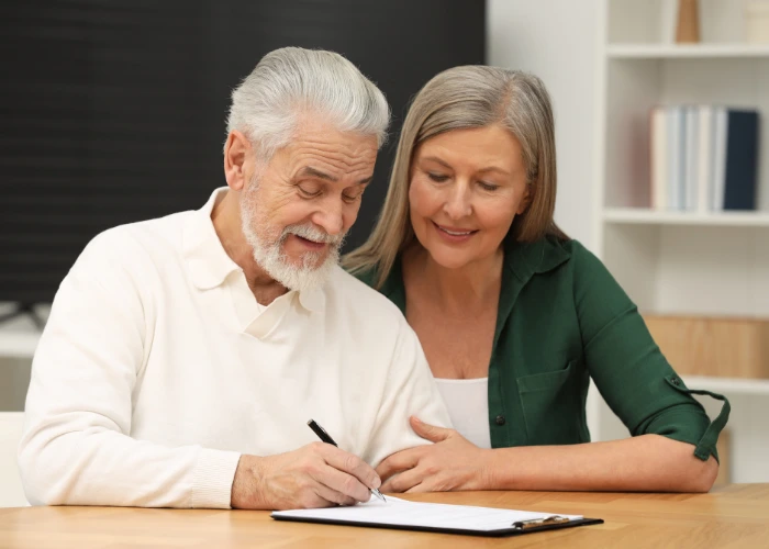 Older couple signing documents together